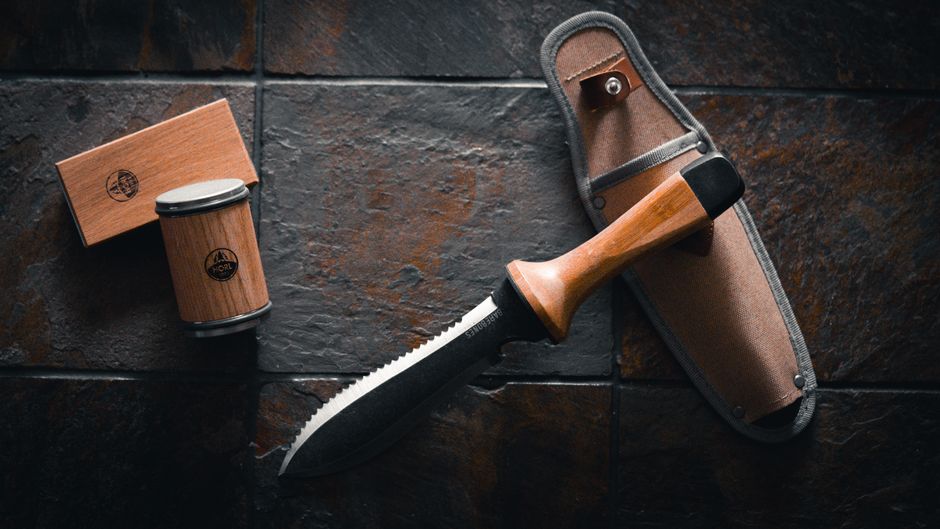 Elegant hori hori garden tool with matching wooden rolling sharpener for gardening enthusiasts.